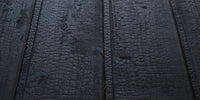 Yakisugi Sumi — close-up of pure-charred Japanese cedar boards with intact alligator-skin char texture